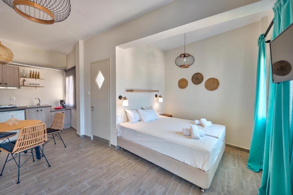 a bedroom with a bed and a table and a kitchen at Guesthouse ERI in Kini