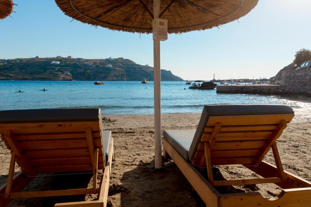 two chairs and an umbrella on a beach at Guesthouse ERI in Kini