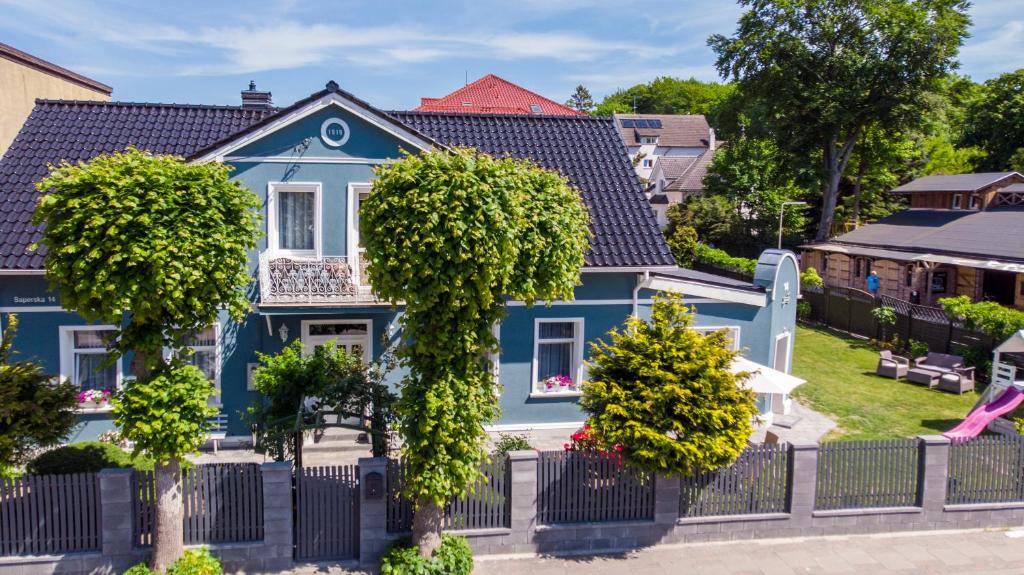 une maison bleue avec des arbres devant elle dans l'établissement Pod Lipami, à Rewal