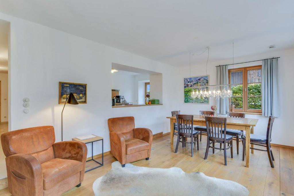 a dining room and living room with a table and chairs at Ferienwohnung Rote Res Alte Gendarmerie Übersee in Übersee