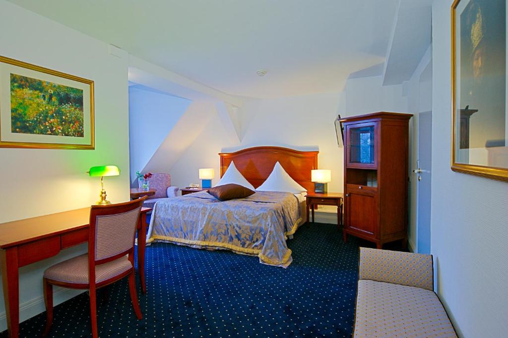 Postel nebo postele na pokoji v ubytování KurparkHotel Warnemünde