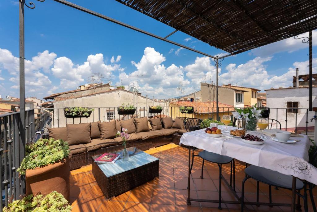 a patio with a couch and a table on a balcony at Charming Attic Niche in Florence