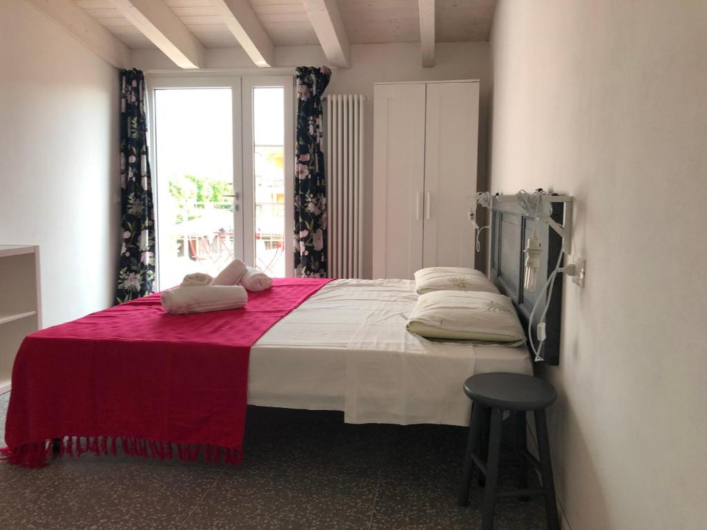 una camera da letto con un grande letto con una coperta rossa di B&B Corte del Garda a Castelnuovo del Garda