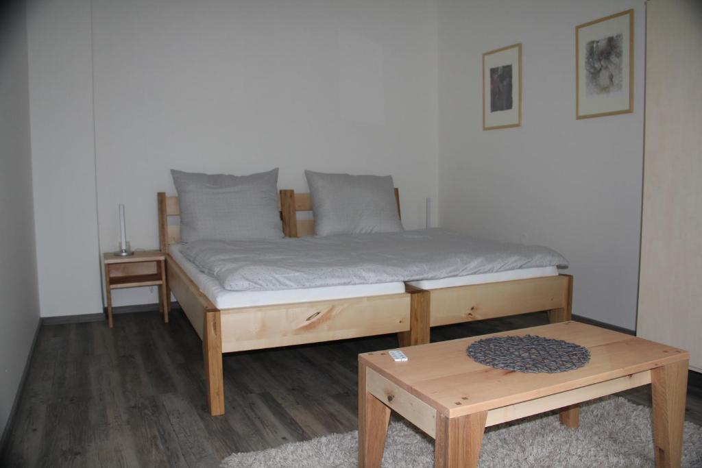a bed in a room with a table and a bed at pAt - a spacious place near the station and center in Spišská Nová Ves