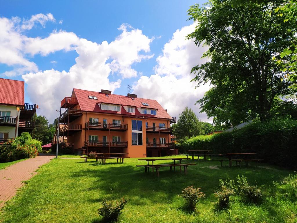 a building with picnic tables in front of it at Wiking in Kretowiny