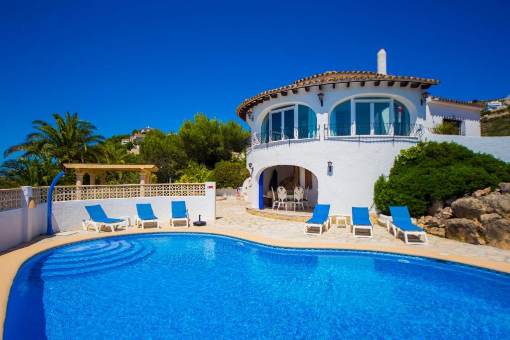 a villa with a swimming pool in front of a house at Mirador al Sur in Moraira