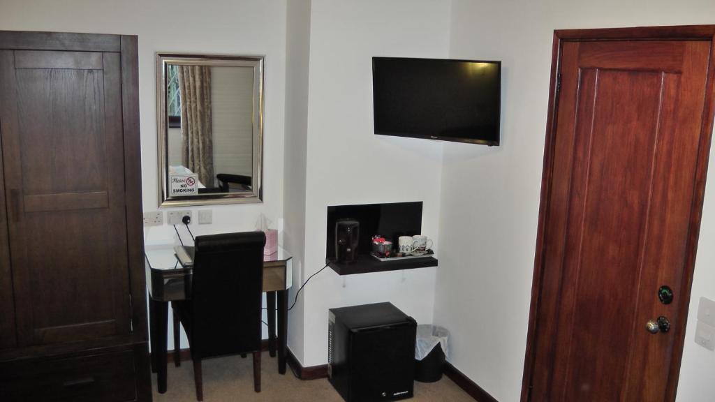 a room with a table and a television on a wall at Bay Lodge in Birchington