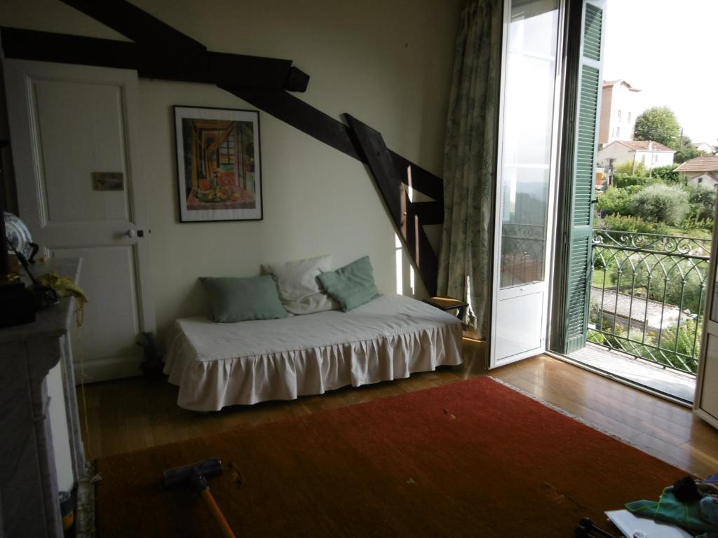 1 dormitorio con 1 cama en una habitación con balcón en Cottage Massanet, en Grasse