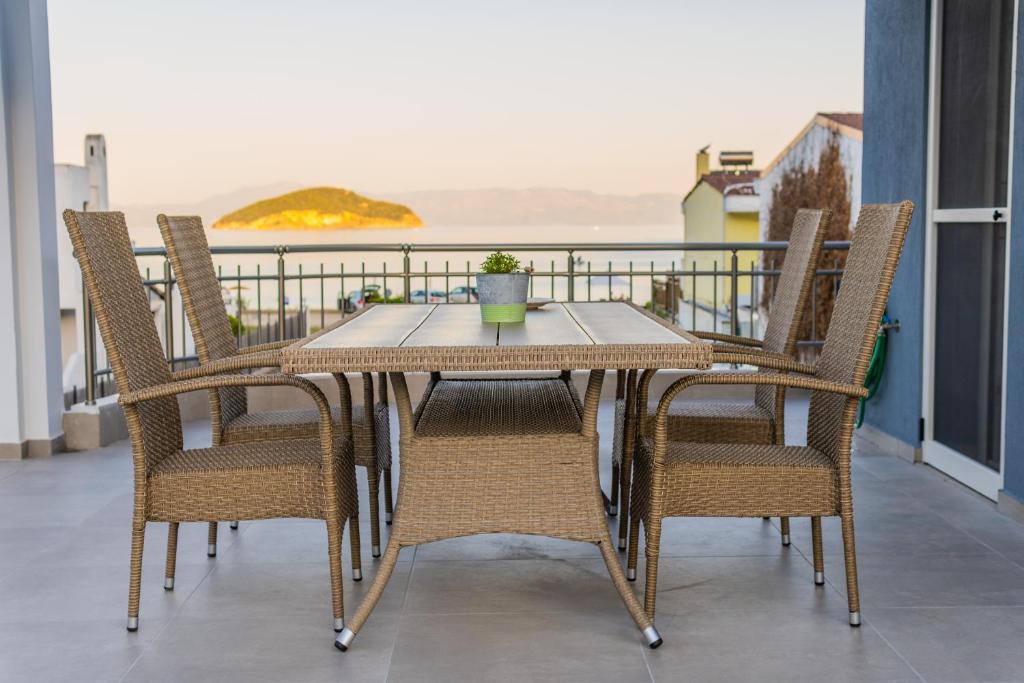 a table and chairs on a balcony with a view of the ocean at Yiasemi Apartments in Iraklitsa