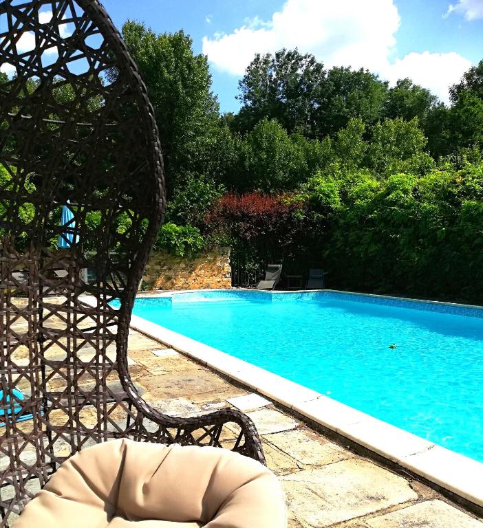 un banc assis devant une piscine dans l'établissement Hôtel-Restaurant Ricordeau, à Loué