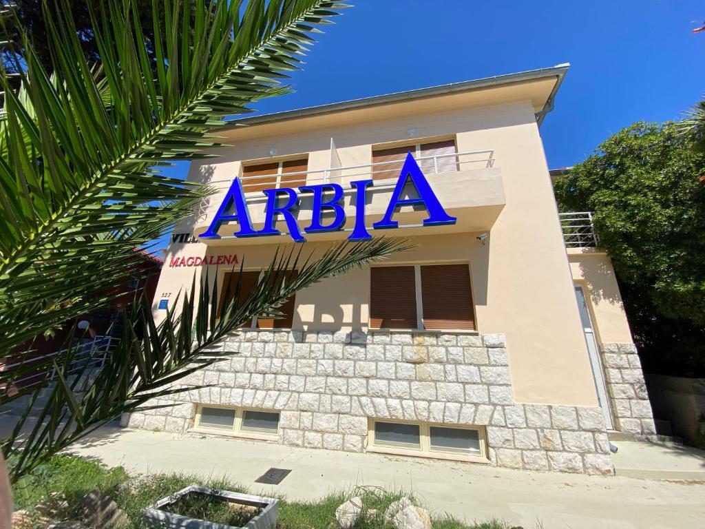 a building with a sign on the side of it at Villas Arbia - Magdalena by the Beach in Rab