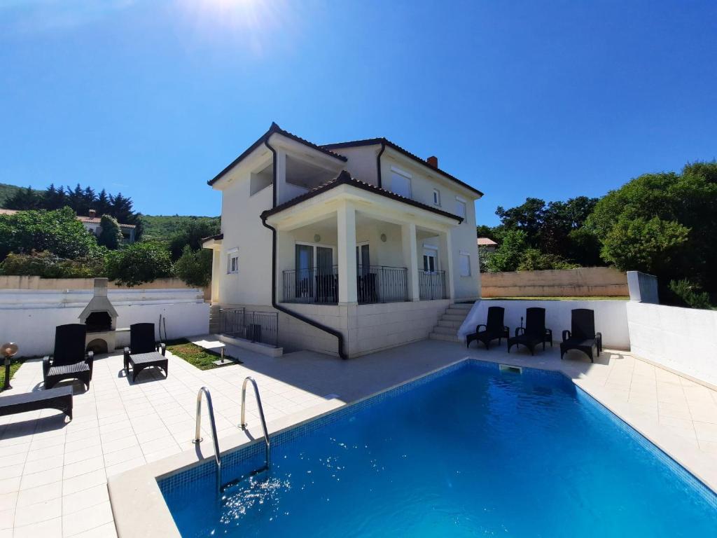 a villa with a swimming pool and a house at Villa Smilje YourCroatiaHoliday in Drenje
