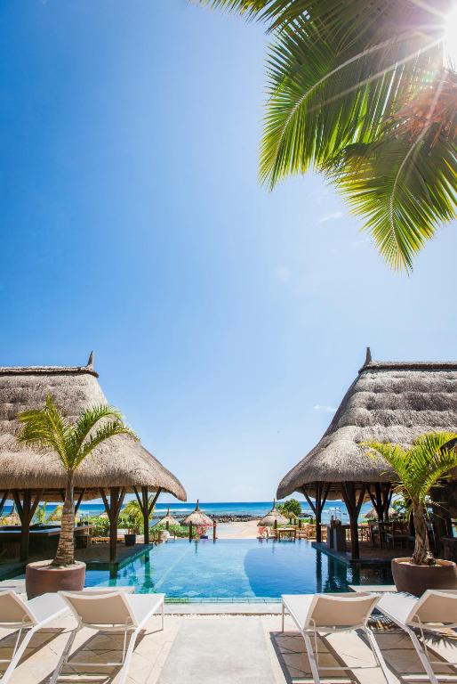 a resort with a pool and chairs and the ocean at Veranda Pointe Aux Biches Hotel & Spa in Trou aux Biches