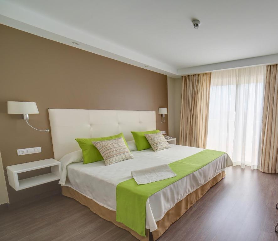 a bedroom with a large bed with green pillows at RF San Borondon in Puerto de la Cruz