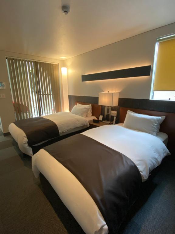 Postel nebo postele na pokoji v ubytování Hotel 草石庵