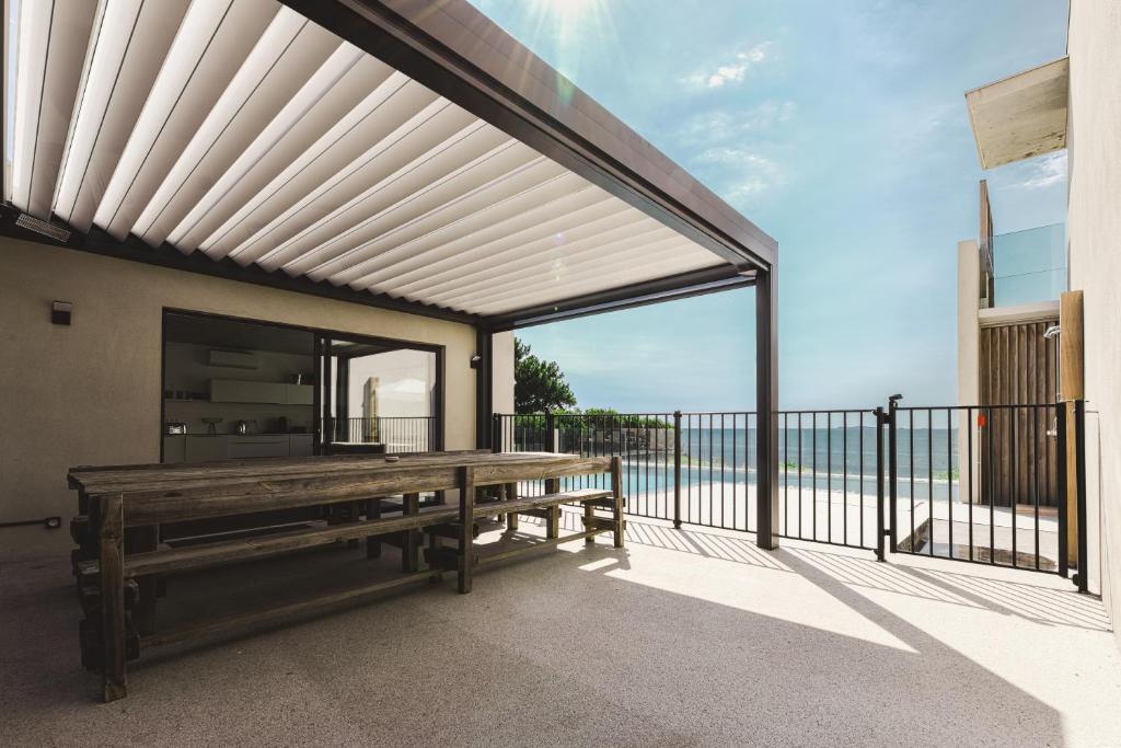 a patio with a wooden bench on a balcony at Hotel le Jardin d'Emile in Porticcio