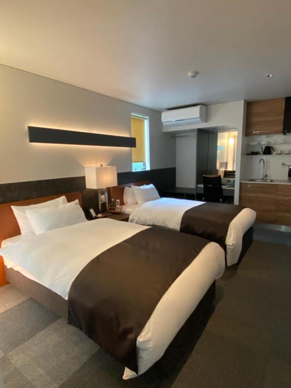 Postel nebo postele na pokoji v ubytování Hotel 草石庵