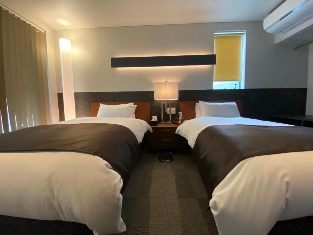 Postel nebo postele na pokoji v ubytování Hotel 草石庵