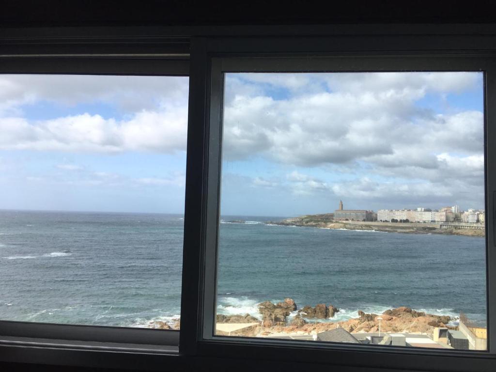 uma vista para o oceano a partir de uma janela em Centrico. Primera linea e impresionantes vistas al mar na Corunha
