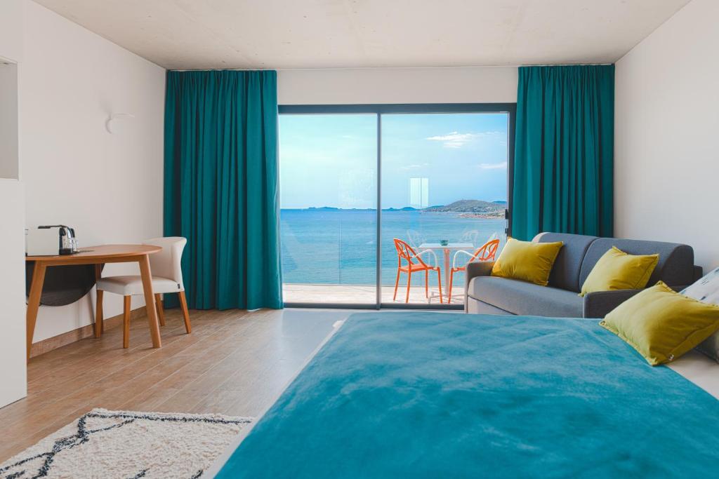 a bedroom with a bed and a living room with a view at Hotel le Jardin d'Emile in Porticcio