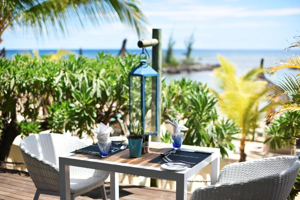 a table with two chairs and a lamp on a patio at Veranda Pointe Aux Biches Hotel & Spa in Trou aux Biches