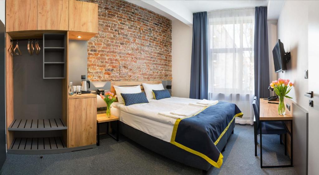 a bedroom with a bed and a brick wall at Hotel Mokotów in Warsaw