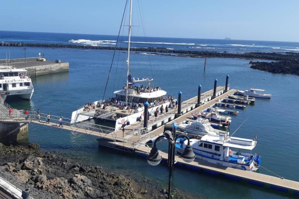 een groep boten aangemeerd op een dok in het water bij APARTAMENTO ROQUE DEL ESTE in Orzola