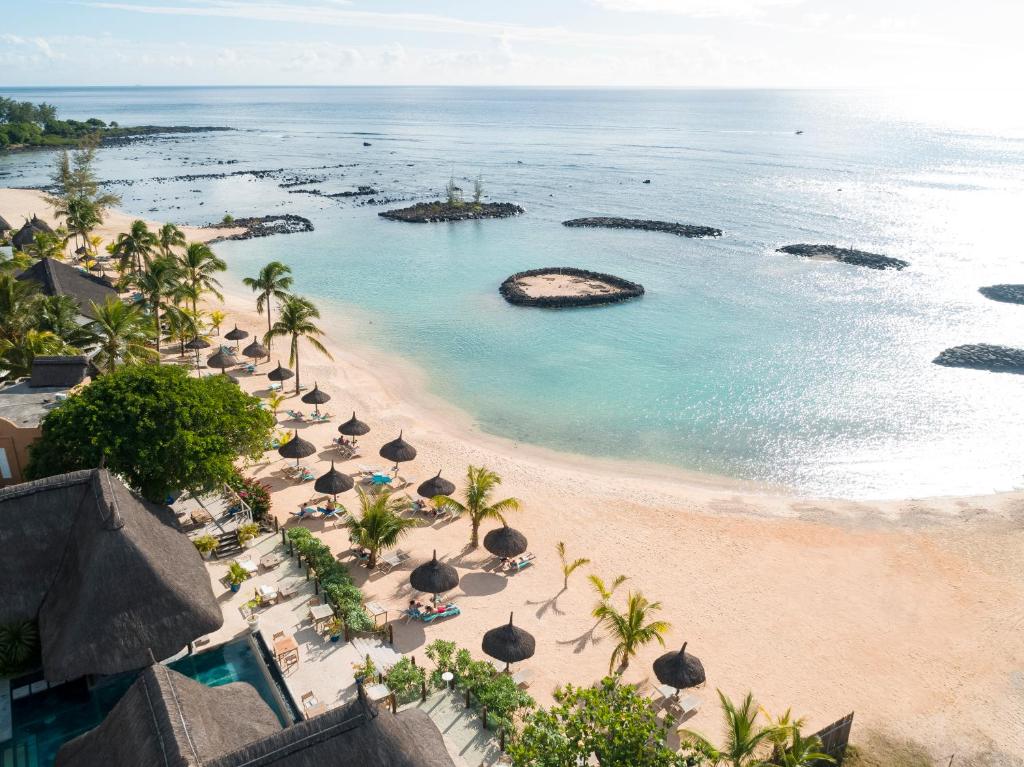 een luchtzicht op een strand met parasols en de oceaan bij Veranda Pointe Aux Biches Hotel & Spa in Trou aux Biches