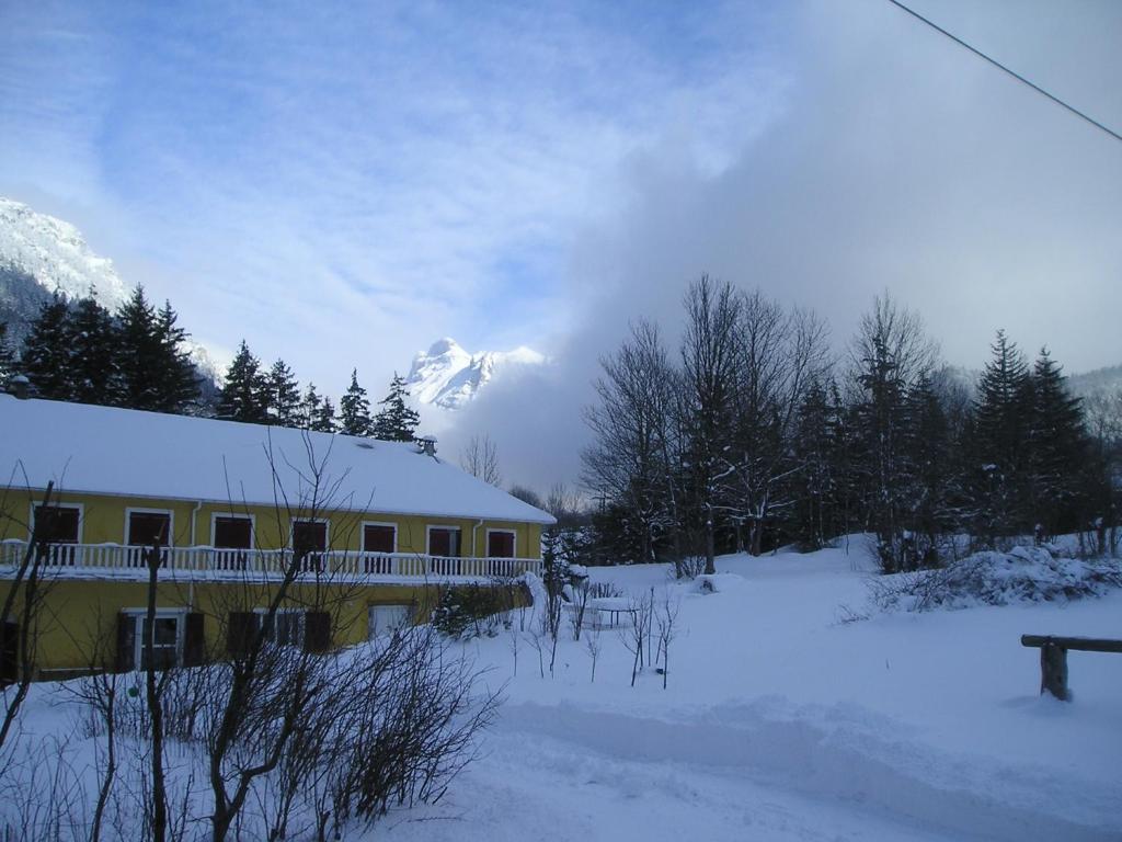 a house in the snow with a mountain in the background at L Acacia in Lus-la-Croix-Haute