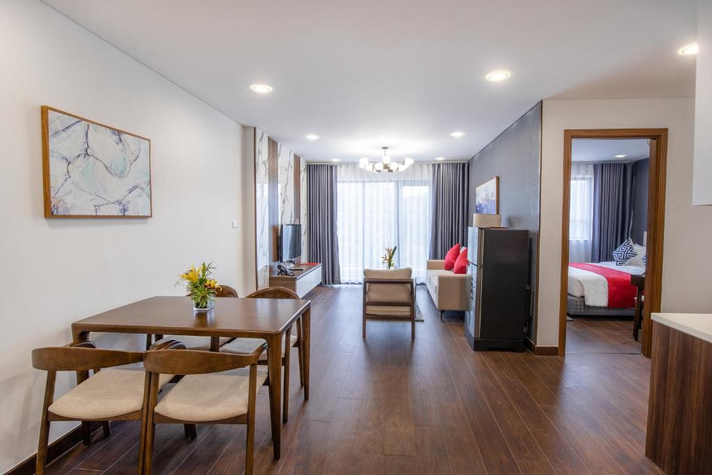 1 dormitorio y sala de estar con mesa de comedor. en Ramada Hotel & Suites by Wyndham Halong Bay View en Ha Long
