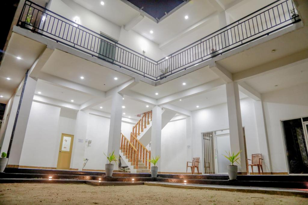 a large white building with stairs and chairs at Araliya Lagoon Park Resort in Negombo