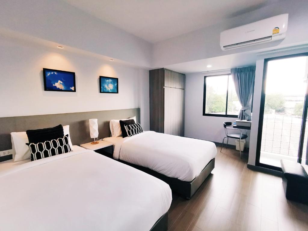 A two-bed room with bright windows, balcony doors and a small work corner.