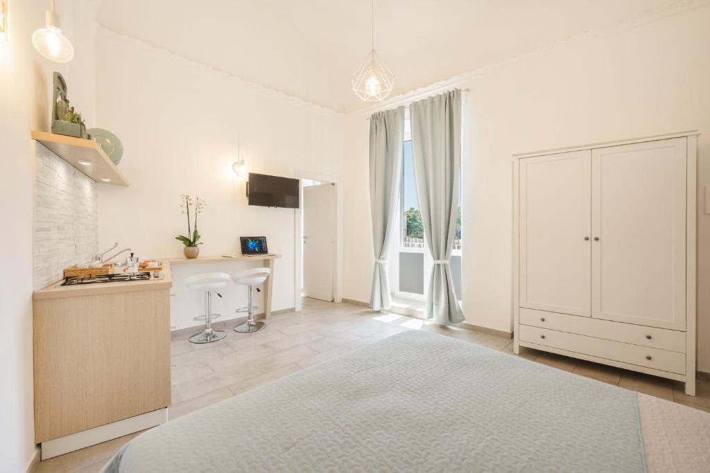 a white kitchen with a white cabinet and a desk at Le Volte Procida Home in Procida