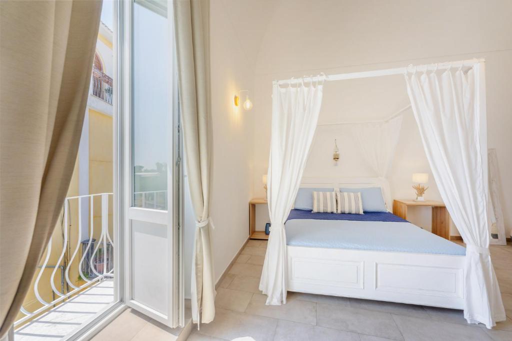 a bedroom with a bed and a balcony at Le Volte Procida Home in Procida