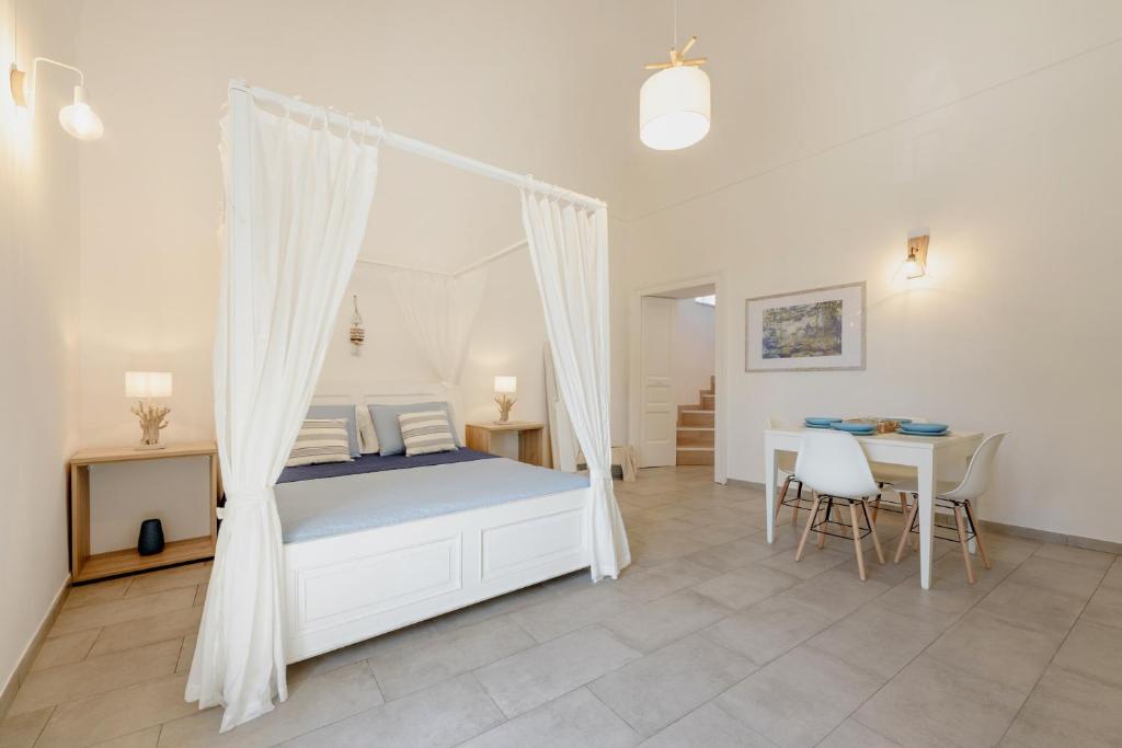 a bedroom with a canopy bed and a table and chairs at Le Volte Procida Home in Procida