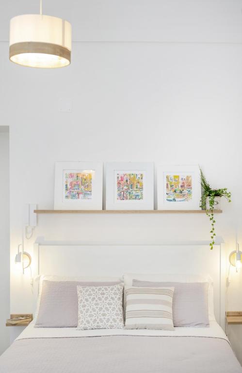 a bedroom with a white bed with a white headboard at Le Volte Procida Home in Procida
