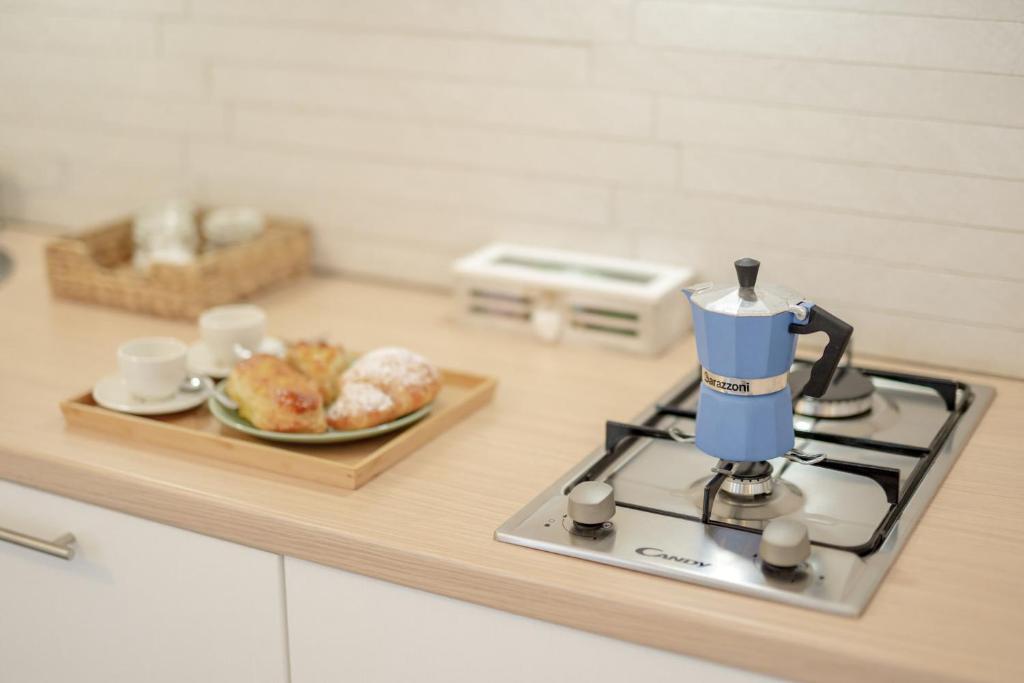 a kitchen counter with a coffee maker and a plate of food at Le Volte Procida Home in Procida