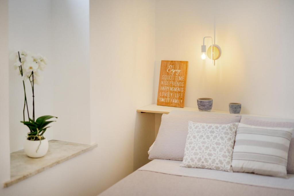 a bedroom with a bed and a vase with flowers at Le Volte Procida Home in Procida