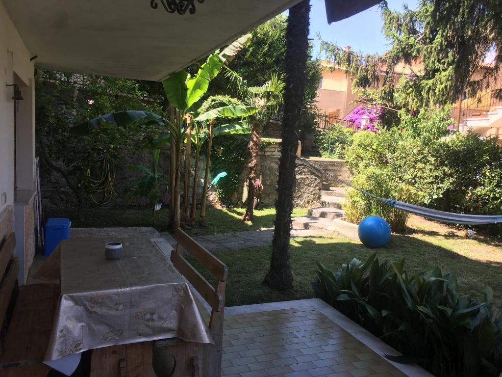 a patio with a table and a hammock in a yard at Oasi in Malcesine