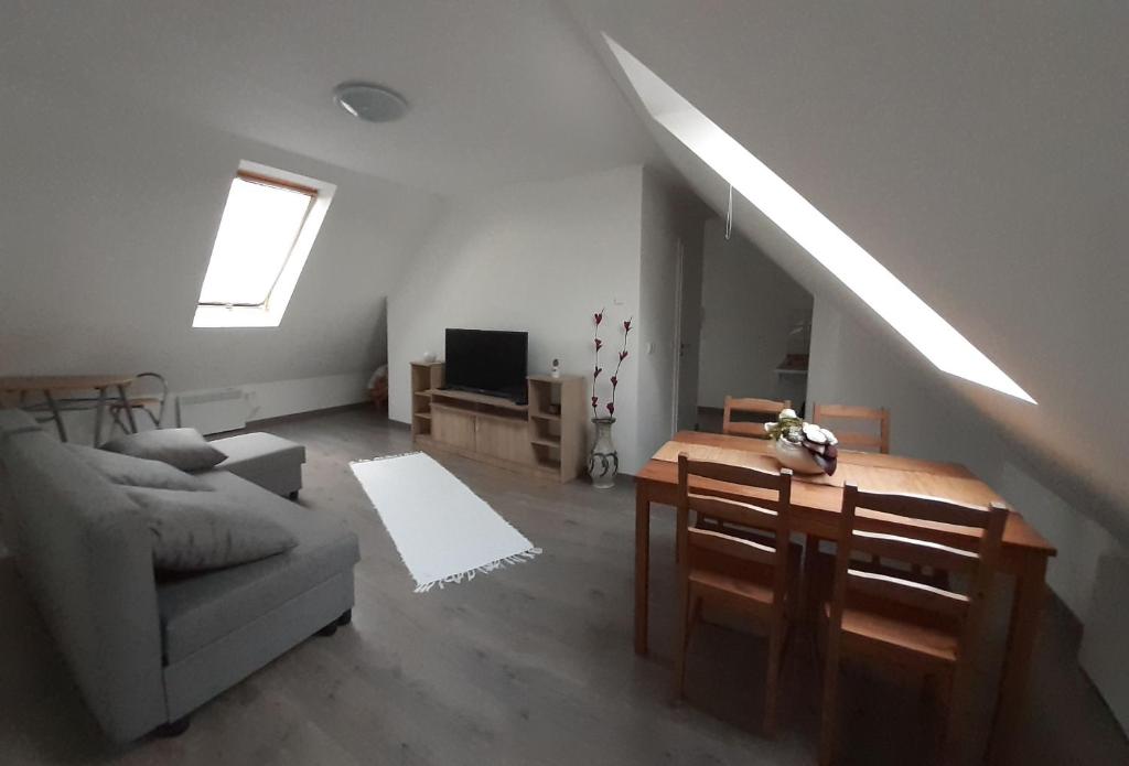 salon z kanapą, stołem i oknem w obiekcie Peak Apartman w Egerze