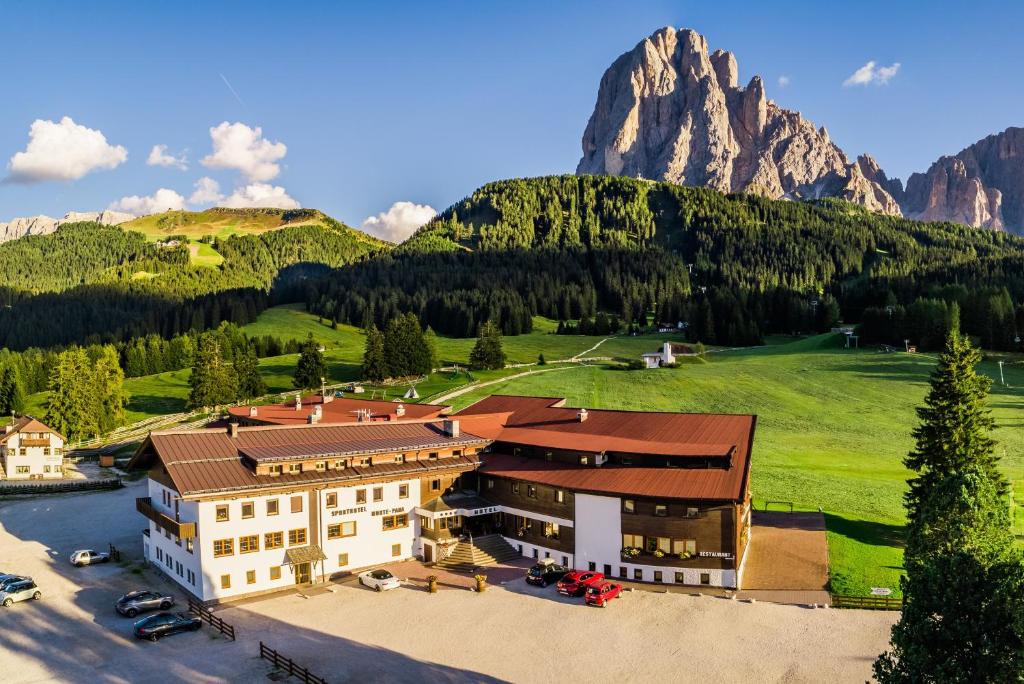 an aerial view of a hotel with mountains in the background at Monte Pana Dolomites Hotel in Santa Cristina in Val Gardena