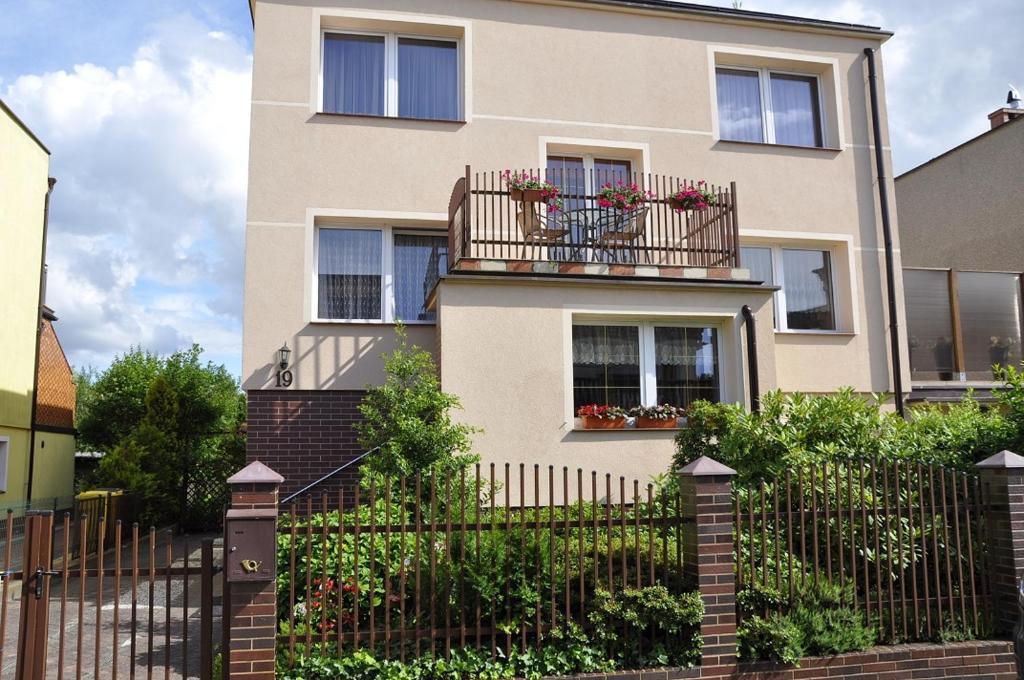 a house with a fence and a balcony with flowers at Willa Zuza in Kołobrzeg