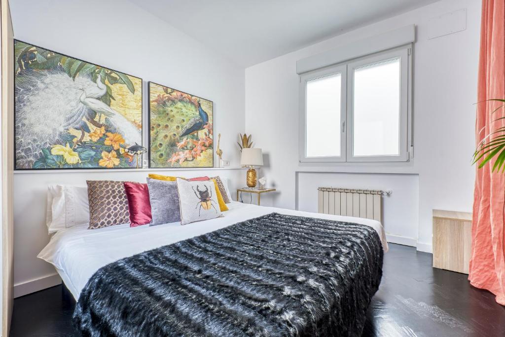 1 dormitorio con 1 cama grande y almohadas coloreadas en El Rastro boutique, en Madrid