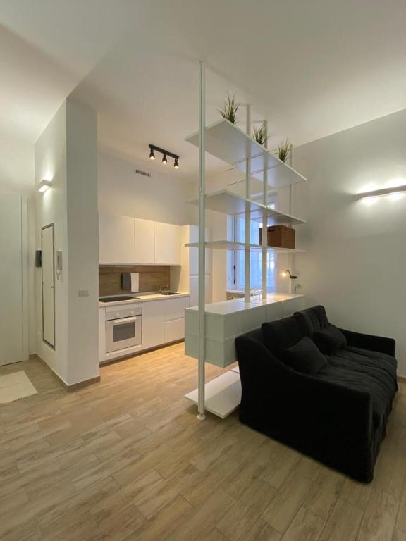 a living room with a black couch and a kitchen at Residenza Idra in Segrate