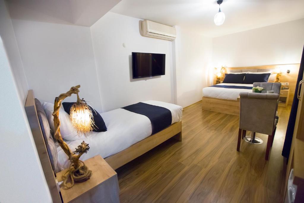 um quarto com 2 camas e uma mesa com uma cadeira em Golden Street Hotel em Istambul