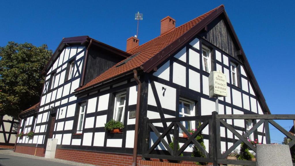 un bâtiment noir et blanc avec un toit dans l'établissement Dom Gościnny Flauta II, à Ustka