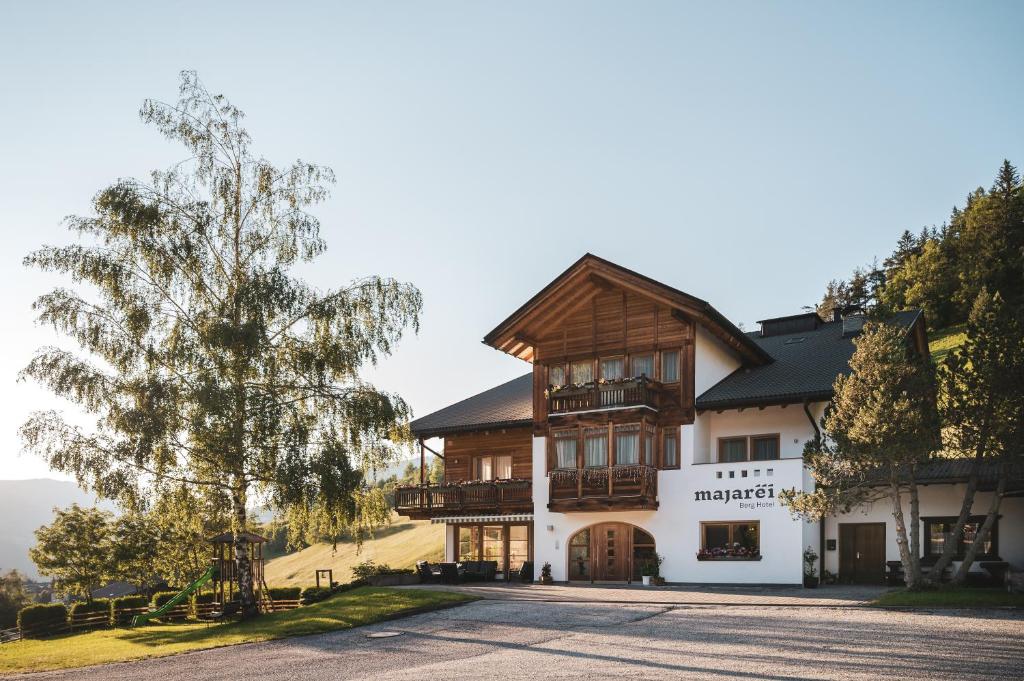 una casa en una colina con un camino delante en Albergo Majarei, en San Vigilio Di Marebbe