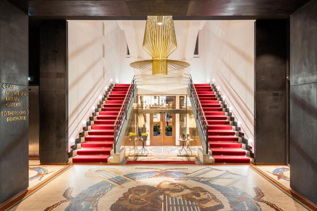 eine Treppe in einem Gebäude mit roten Treppen und einem Teppich in der Unterkunft MOSAIC HOUSE Design Hotel in Prag