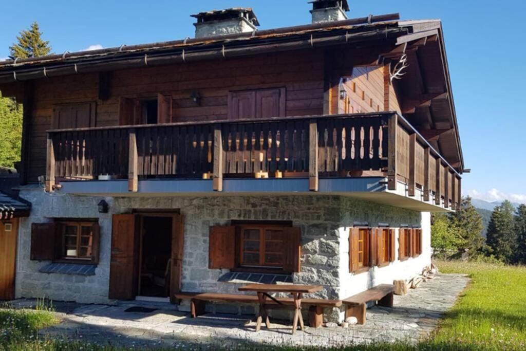 une cabane en rondins avec une table de pique-nique devant elle dans l'établissement Chalet Wulli in der Nähe der Skianlagen Savognin, à Savognin