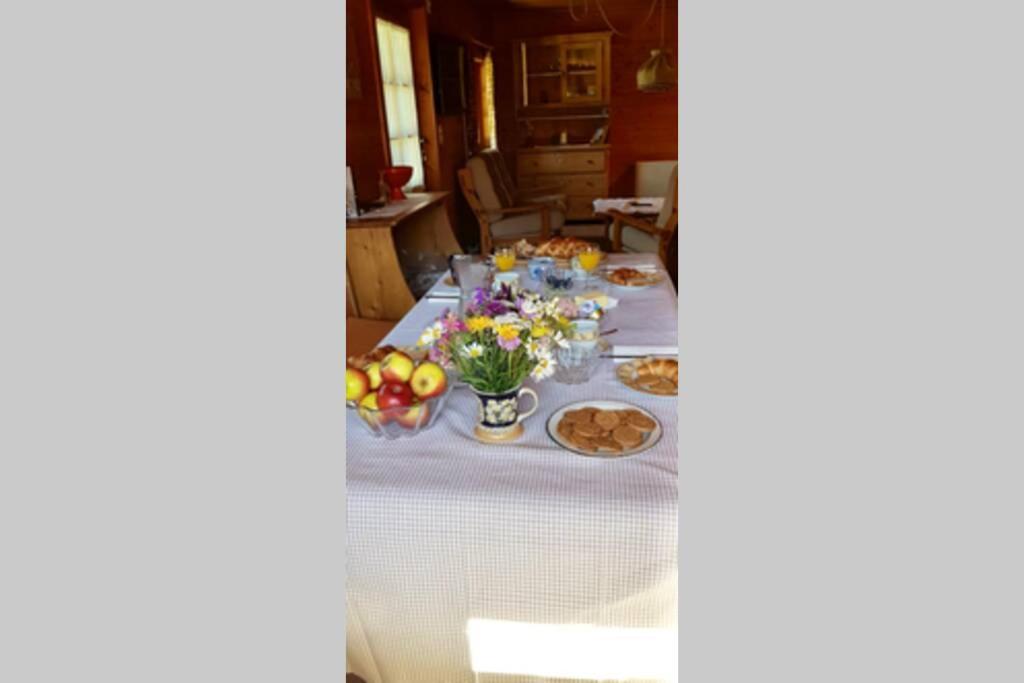 a table with food and flowers on it at Chalet Wulli in der Nähe der Skianlagen Savognin in Savognin